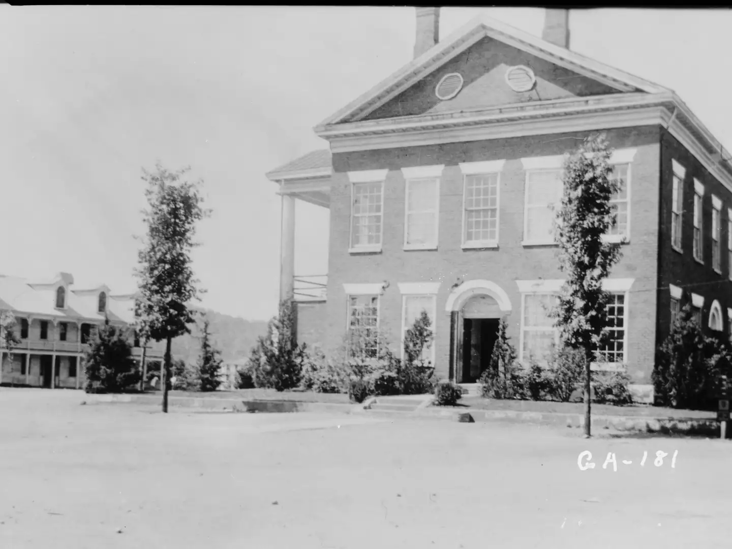 1936 black-and-white HABS photo of the Lumpkin County Courthouse in Dahlonega, a brick building with two chimneys on an unpaved square.
